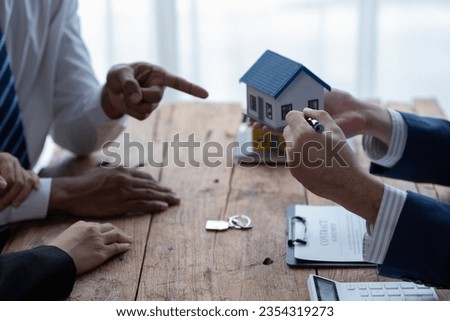 Close up focus on small house model standing on table with clients signing contract agreement with real estate agent, purchasing own dwelling apartment, professional service concept.