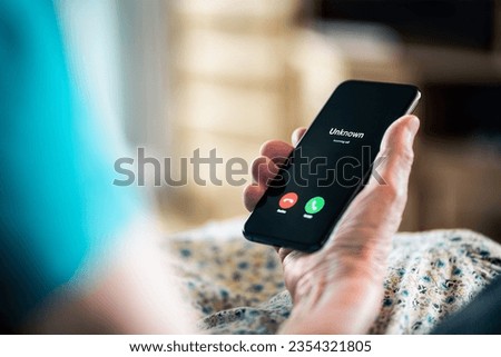 Old woman and phone call with hidden mobile number. Senior mature lady and fraud and scam caller. Love and romance hoax. Holding smartphone in hand. Catfish or scammer. Phishing concept. Royalty-Free Stock Photo #2354321805