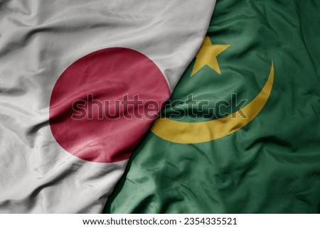 big waving national colorful flag of japan and national flag of mauritania . macro