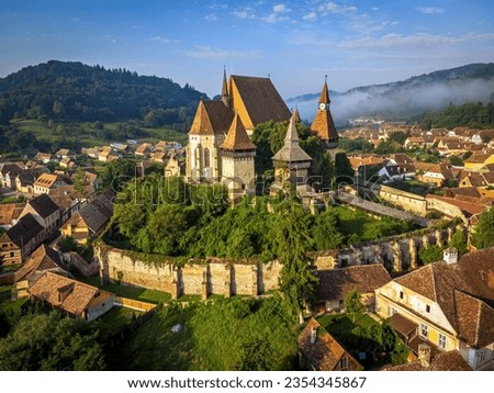 The medieval Saxon village of Biertan and its fortified church during a dreamy morning. Photo taken on 17th of August 2023 in Biertan, Sibiu County, Romania. Royalty-Free Stock Photo #2354345867