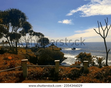The rugged cliffs, inviting picnic spots, lush green grass, charming gazebo, and the backdrop of a serene blue sky with scattered clouds create a picture-perfect scene