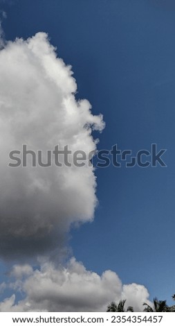 Majestic white fluffy clouds sailing on the endless Blue sky in a bright sunny day. Blue background, peaceful picture, vertical image. Love to take pictures of Sky. Beautiful nature 