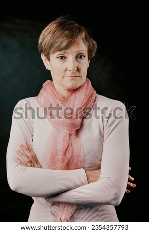 A striking elderly lady in a pink sweater exudes an air of distrust and disapproval. She firmly stands against men's domineering tendencies and the young's libertine actions. It's not alright Royalty-Free Stock Photo #2354357793