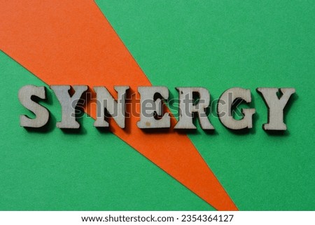 Synergy, word in wooden alphabet letters isolated on orange and green background as banner headline