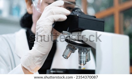 Scientist in laboratory use microscope delving into the realms of biology, biotechnology, and microbiology with expertise in chemistry, medicine, research involves meticulous experiments and analysis