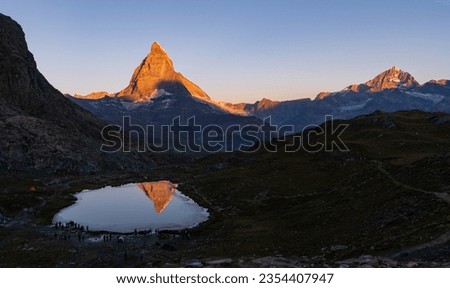 sunrise at Riffelsee early in the morning with a beautiful view of the Matterhorn with a burning top and the reflection in the lake in Zermatt, Switzerland