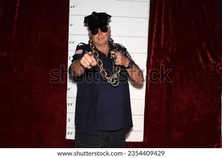 Photo Booth. A man Smiles and Poses while his Pictures are taken in a Photo Booth at a Wedding or Birthday Party. People love to dress up in Costumes and have their Photos Taken in Photo Booths. 