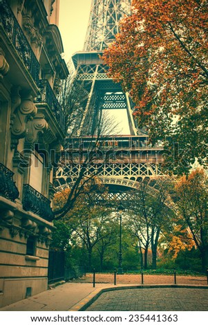 Eiffel Tower between city buildings in autumn