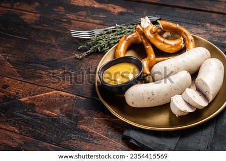 Munich white sausage with pretzel and mustard. Wooden background. Top view. Copy space. Royalty-Free Stock Photo #2354415569