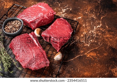 Raw Wild Game Meat of Venison dear ready for cooking. Dark background. Top view. Copy space.