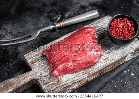 Raw Venison dear steak ready for cooking. Black background. Top view. Royalty-Free Stock Photo #2354416697