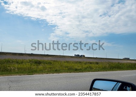  Dump trucks with a trailer carrying goods on a highway
Blue sky over a truck on the highway, side view.
