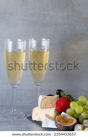 Assortment of cheese with fruits, grapes and white wine.