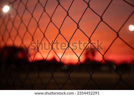 Juan José Castelli, Chaco, Argentina. August 27, 2023. A fence of a soccer field during a red sunset in the Chaco.