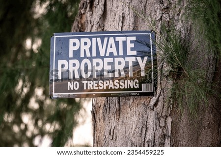 Closeup of a private property no trespassing sign attached to a tree