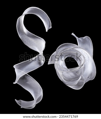 White ribbon long straight fly in air with curve roll shiny. White snow ribbon for present gift birthday party to wrap around decorate, curl curve long straight. Black background isolated