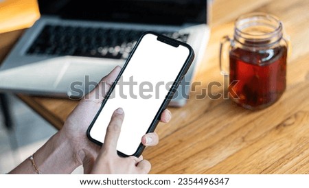female hands holding phone with isolated screen over table in cafe