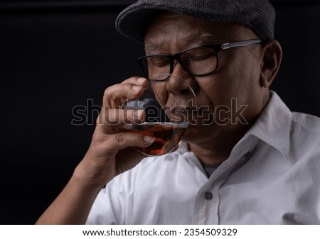 Asian senior man drinking whiskey on black screen