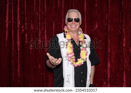Photo Booth. Hawaiian Style. A man smiles as he wears a Hawaiian style shirt and waits for his pictures to be taken while in a Photo Booth. Everyone Loves a Photo Booth. Maui, Hawaii. Hawaiian Photos.