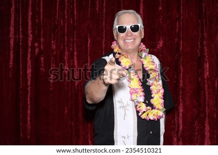 Photo Booth. Hawaiian Style. A man smiles as he wears a Hawaiian style shirt and waits for his pictures to be taken while in a Photo Booth. Everyone Loves a Photo Booth. Maui, Hawaii. Hawaiian Photos.