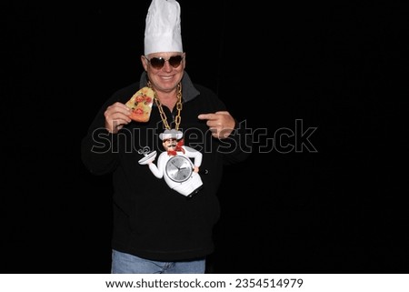 Photo Booth. A man wears a Chef Hat and a Chef Clock Necklace while waiting for his pictures to be taken in a Photo Booth. Everyone loves a Photo Booth even Chefs and Fast Food Cooks. Beer Mug. Pizza.
