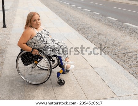 Smiling Young Pretty Woman With Short Stature On Wheelchair Stands On Bus Stop Outdoor Waiting For Public Transport At Summer Day. Female Adult With Disability. Copy Space For Text. Horizontal Plane. Royalty-Free Stock Photo #2354520617