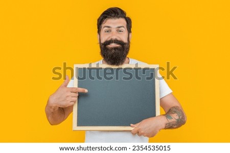 photo of man offer advertisement pointing at blackboard isolated on yellow background