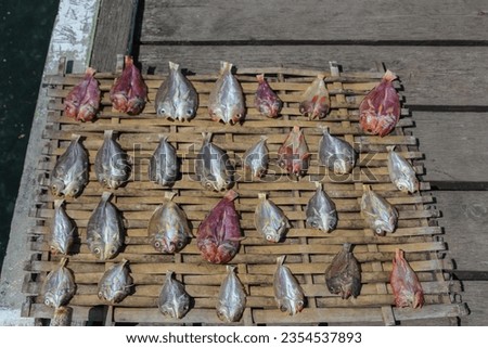 Sea fish that has been split on woven bamboo and dried under the hot sun