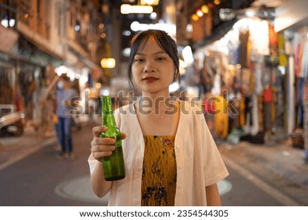 Drunk alcoholic woman Asian Vietnamese woman travel at night, drinking beer in market. People walking street fair in Hanoi city, Vietnam. Retail shops
