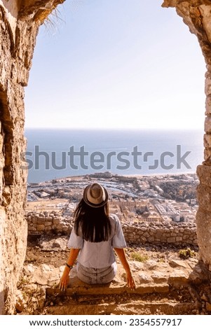 Young tourist woman and sea landscape with Terracina, Lazio, Italy. Scenic resort town village with nice sand beach and clear blue water. Famous tourist destination in Riviera de Ulisse Royalty-Free Stock Photo #2354557917