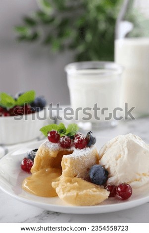 Tasty vanilla fondant with white chocolate, berries and ice cream on white marble table, closeup. Space for text