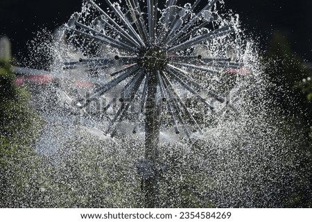 creative drops of water fly in different directions in a modern fountain during the summer heat