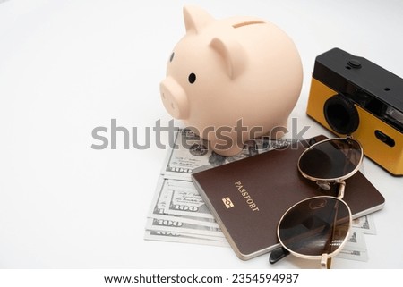 Travel planning and budget concept. Film Camera, Passport, piggy bank, Sunglasses and collecting money for vacation trip. Preparing for vacation. Royalty-Free Stock Photo #2354594987