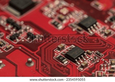 Shallow focus close-up shot of electronic circuit board components in red. Perfect for backgrounds on technology-related topics. Depending on our experiences and ideas, we can interpret many meaning. Royalty-Free Stock Photo #2354595055
