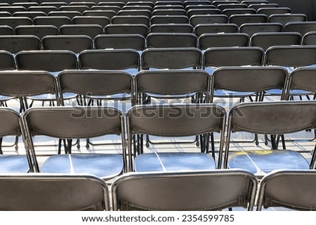 Rows of black chairs stand in the auditorium for the audience.