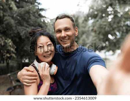 Joyful Sporty young Couple Taking Selfie On Smartphone After Training In Park, Posing For Photo On Path Outdoors. 