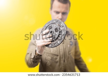 clutch disc in the hands of an auto mechanic, the concept of replacing the clutch in a car.
