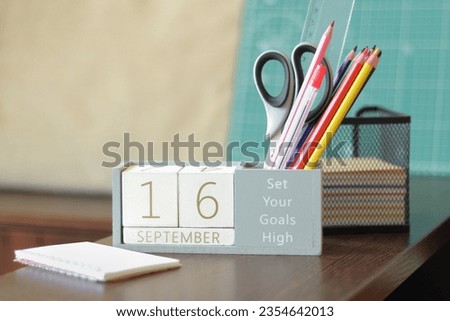 16 September. Image of september 16 wooden calendar on desktop. Autumn day. Back to school. Pencils and paints, stationery