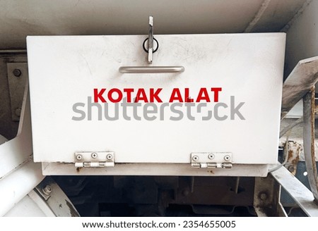white tool box made of iron and reads "tool box" in Indonesian translation