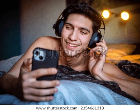 Cheerful man in headphones with smartphone listening to music