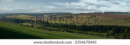 A wide panorama of plowed fields.Endless field horizon. Landscape picture in the field.