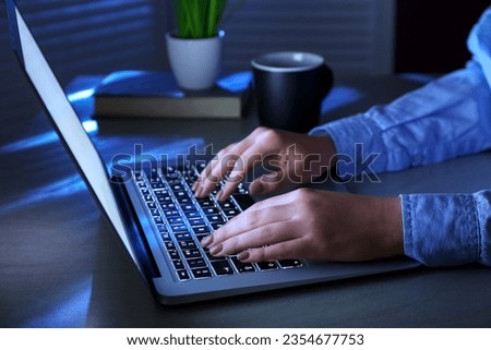 Woman working with modern laptop in evening on comfortable workplace