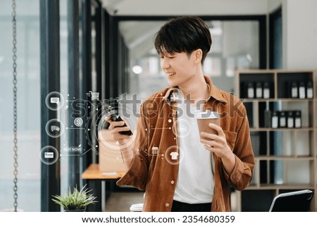 Man using smart phone for mobile payments online shopping, omni channel, sitting on table, virtual icons graphics interface 