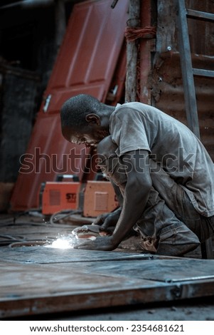 elderly, experienced welder absorbed in his work designing a steel door, his face lit up by the sparkling lights