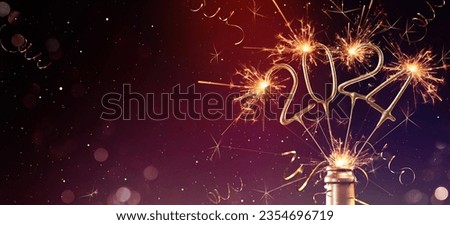 Happy New Year 2024, New Year's Eve Party background greeting card, sparklers in champagne bottle and bokeh lights on dark night sky Royalty-Free Stock Photo #2354696719