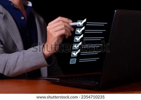 Businessman marks the checklist for document control, online product quality and business approval. Royalty-Free Stock Photo #2354710235
