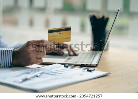 Young woman holding credit card and using laptop computer to shop online, online shopping concept or internet surfing close up pictures