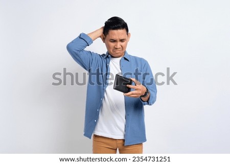No money. Depressed young Asian man in casual shirt looking at empty wallet, having financial problems isolated on white background