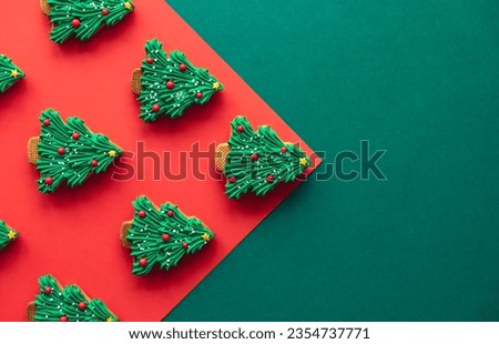 Christmas tree shaped gingerbread cookies covered with icing, flat lay.