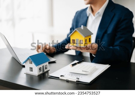 Buying a home or insurance deal, an insurance agent pointing a pen to those interested in renting a house, a contract, signing an Home buying agreement 
